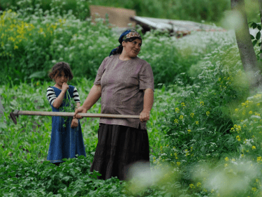 Frau mit Kind in grünem Pflanzenfeld