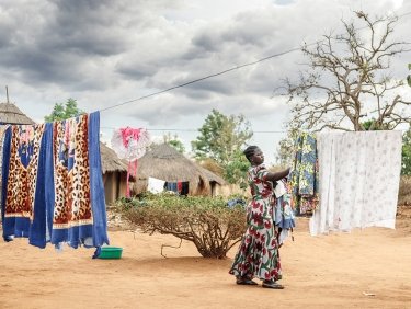 Une femme étend son linge dans un village d'Ouganda