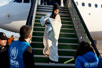 Geflüchtete Frau steigt aus einem Flugzeug